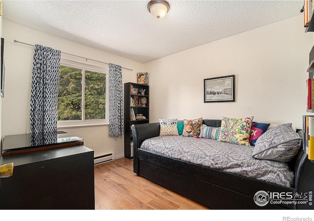 4117 Shannon Dr, Laporte, CO 80535 - bedroom featuring baseboard heating, wood finished floors, and a textured ceiling