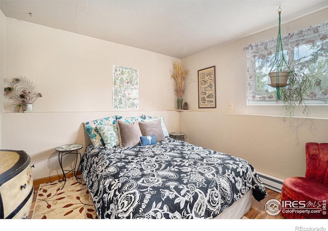 4117 Shannon Dr, Laporte, CO 80535 - bedroom with a baseboard heating unit, wood finished floors, and baseboards
