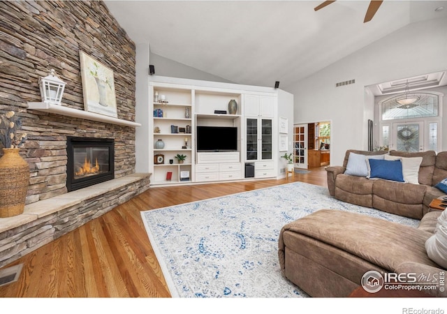 13 Blue Heron Dr, Thornton, CO 80241 - living room with ceiling fan, wood finished floors, a stone fireplace, and high vaulted ceiling