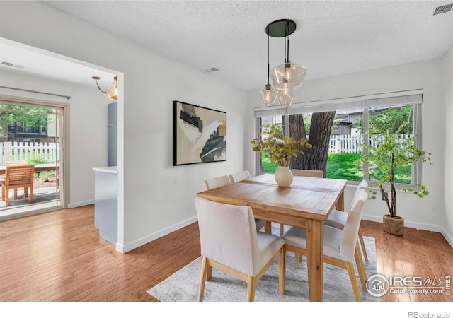 790 W Moorhead Cir # A, Boulder, CO 80305 - dining area featuring a chandelier, healthy amount of natural light, and a textured ceiling
