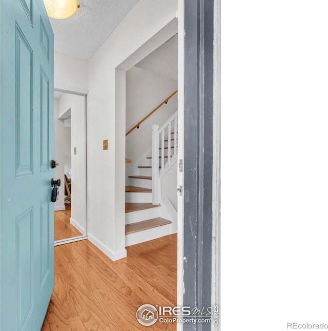 790 W Moorhead Cir # A, Boulder, CO 80305 - entrance foyer with light wood finished floors, baseboards, stairway, and a textured ceiling