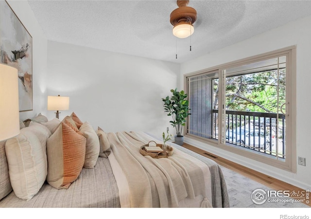 790 W Moorhead Cir # A, Boulder, CO 80305 - bedroom with wood finished floors, a textured ceiling, ceiling fan, and baseboards