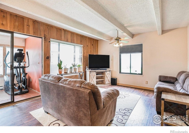 2525 S Dayton Way Unit 2301, Denver, CO 80231 - living room featuring a textured ceiling, wooden walls, a ceiling fan, beamed ceiling, and wood finished floors