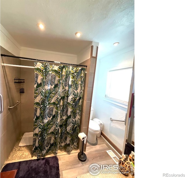 522 K Ave, Limon, CO 80828 - full bath featuring wood finished floors, toilet, a tile shower, baseboards, and recessed lighting