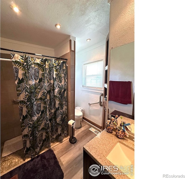 522 K Ave, Limon, CO 80828 - bathroom with wood finished floors, toilet, vanity, a tile shower, and a textured ceiling