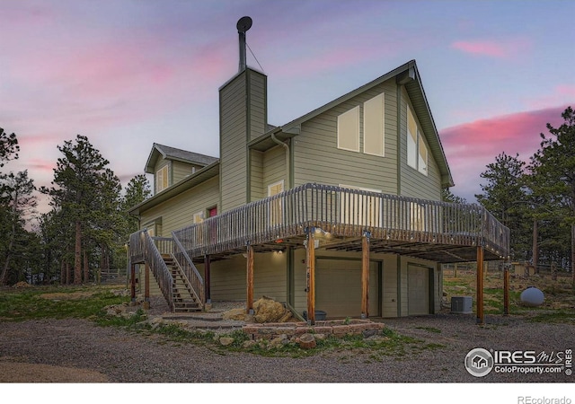 613 Ranch Rd, Ward, CO 80481 - rear view of property featuring cooling unit, a deck, an attached garage, and a chimney