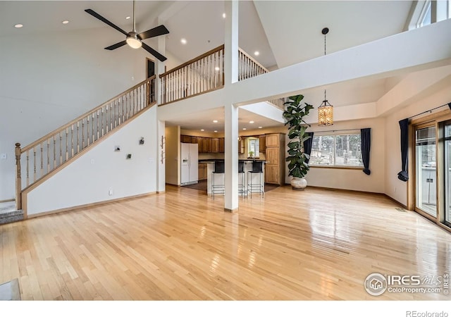 613 Ranch Rd, Ward, CO 80481 - unfurnished living room with light wood finished floors, a towering ceiling, ceiling fan, stairway, and recessed lighting