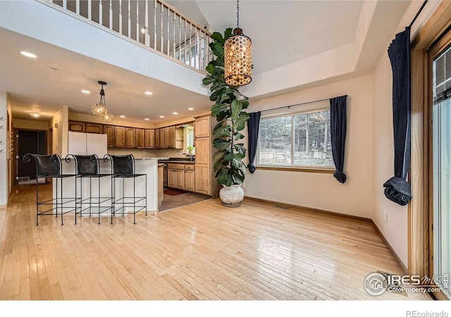 613 Ranch Rd, Ward, CO 80481 - kitchen featuring a chandelier, light wood-style flooring, freestanding refrigerator, baseboards, and a high ceiling
