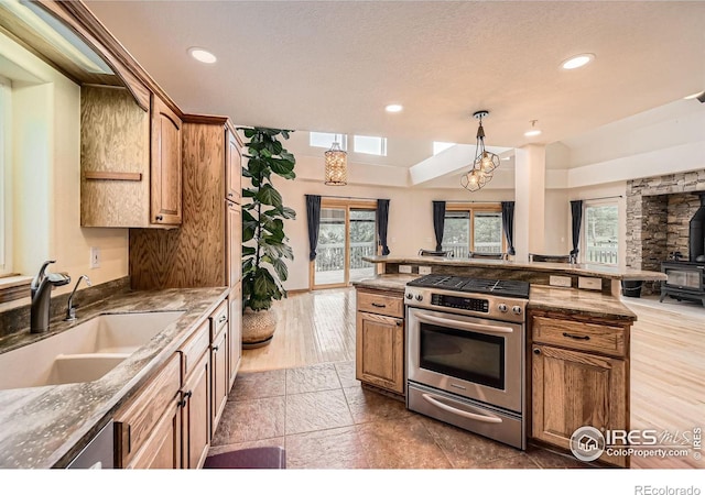 613 Ranch Rd, Ward, CO 80481 - kitchen with stainless steel range with gas stovetop, a sink, a wood stove, open floor plan, and recessed lighting