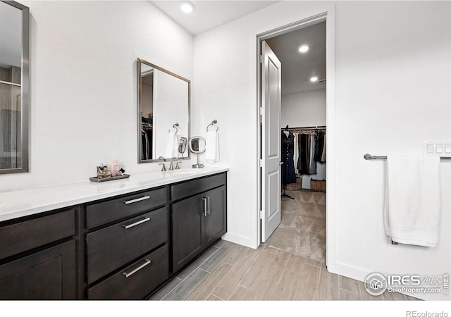 926 Hearteye Trl, Lafayette, CO 80026 - bathroom featuring a spacious closet, vanity, wood tiled floors, recessed lighting, and baseboards