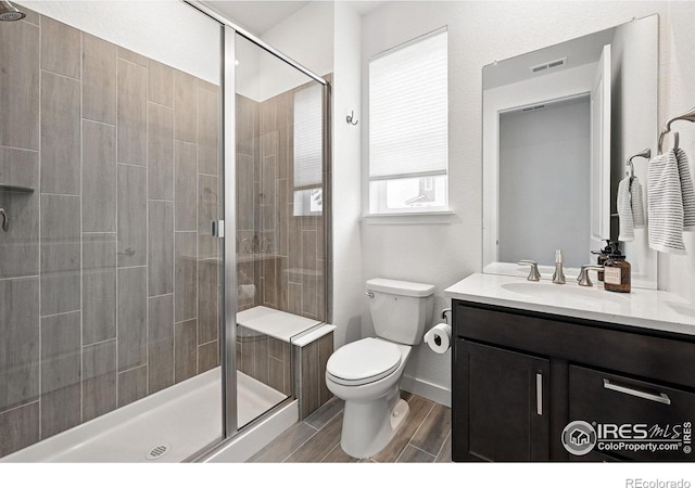 926 Hearteye Trl, Lafayette, CO 80026 - bathroom featuring toilet, vanity, a stall shower, and wood tiled floors