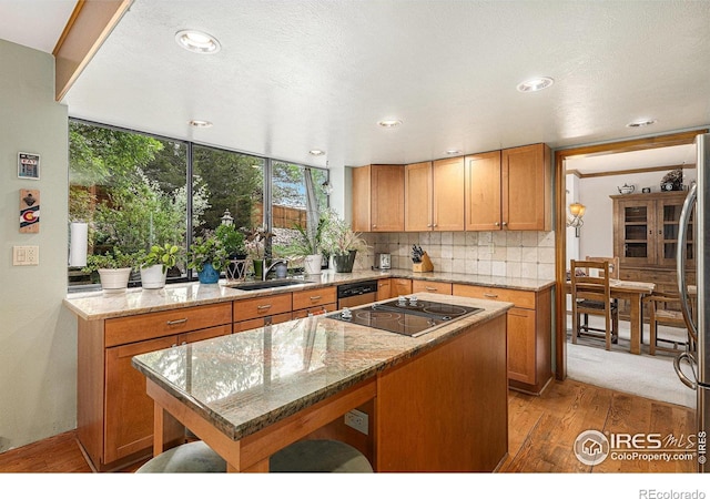 3441 W Dartmouth Ave, Denver, CO 80236 - kitchen featuring a sink, light wood-style floors, backsplash, black electric stovetop, and light stone countertops