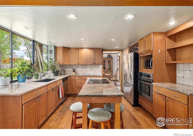 3441 W Dartmouth Ave, Denver, CO 80236 - kitchen with stainless steel appliances, a sink, light wood-style floors, backsplash, and recessed lighting