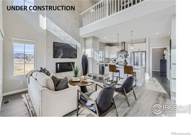 945 Abbott Ln Unit 5, Fort Collins, CO 80524 - living area with a towering ceiling, light wood finished floors, baseboards, and a fireplace