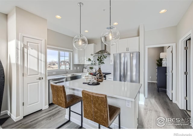 945 Abbott Ln Unit 5, Fort Collins, CO 80524 - kitchen with appliances with stainless steel finishes, wall chimney exhaust hood, light wood finished floors, light countertops, and recessed lighting