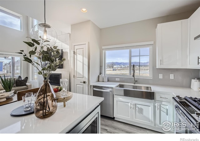 945 Abbott Ln Unit 5, Fort Collins, CO 80524 - kitchen with appliances with stainless steel finishes, a sink, white cabinetry, light countertops, and light wood-type flooring