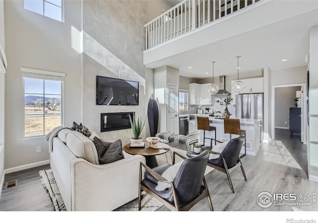 945 Abbott Ln Unit 5, Fort Collins, CO 80524 - living area featuring a high ceiling, light wood-style floors, baseboards, and a tile fireplace