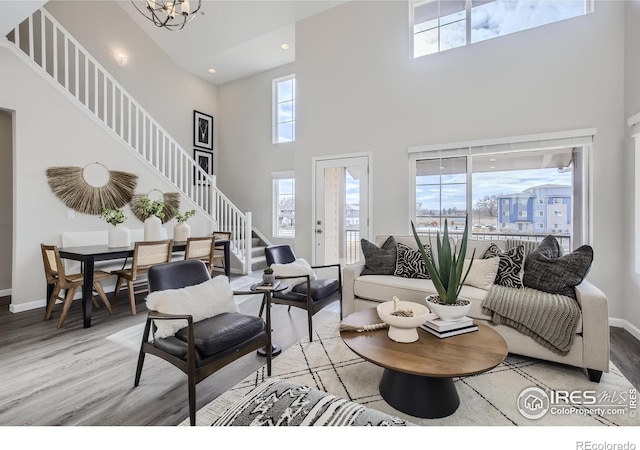 945 Abbott Ln Unit 5, Fort Collins, CO 80524 - living area with stairs, light wood finished floors, a towering ceiling, a chandelier, and baseboards