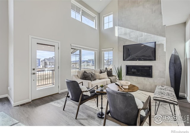 945 Abbott Ln Unit 5, Fort Collins, CO 80524 - living room with wood finished floors, high vaulted ceiling, a tile fireplace, and baseboards