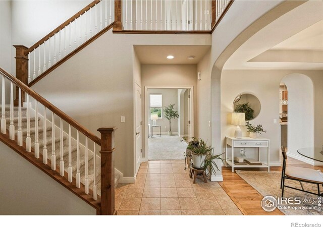 2315 Haymeadow Way, Fort Collins, CO 80525 - entrance foyer with arched walkways, stairway, baseboards, and a high ceiling