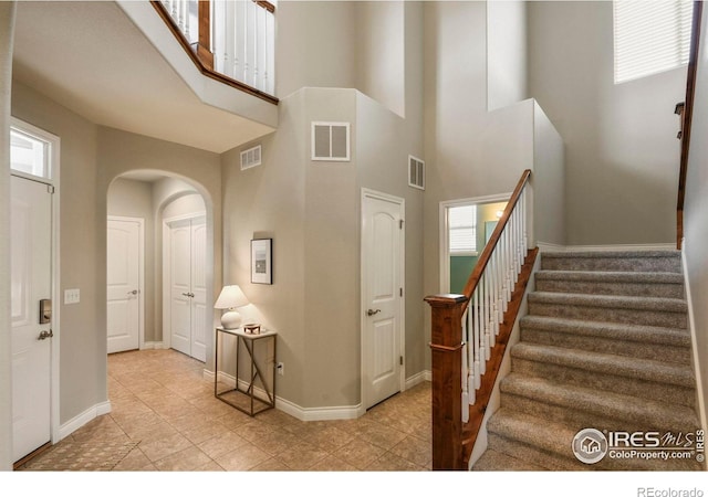 2315 Haymeadow Way, Fort Collins, CO 80525 - stairway featuring a towering ceiling, arched walkways, and baseboards