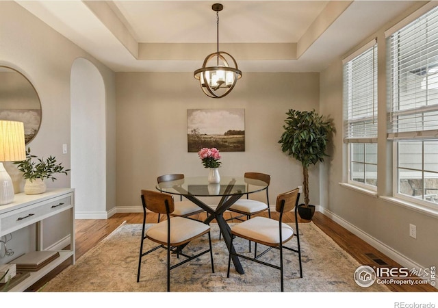2315 Haymeadow Way, Fort Collins, CO 80525 - dining area featuring a raised ceiling, light wood finished floors, baseboards, and a chandelier