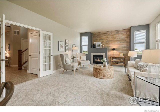 2315 Haymeadow Way, Fort Collins, CO 80525 - living room with stairway, wood walls, a glass covered fireplace, carpet, and baseboards
