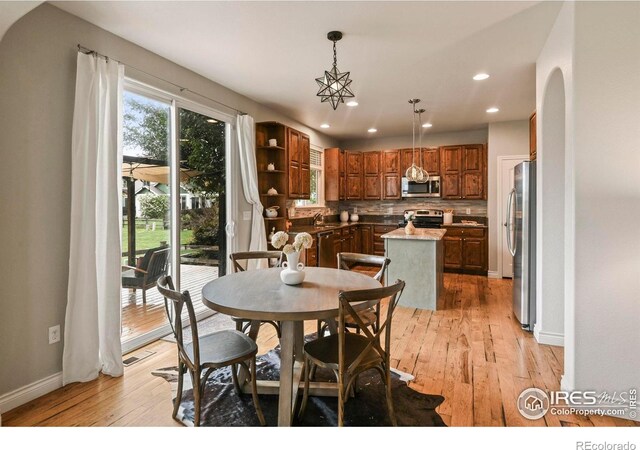 2315 Haymeadow Way, Fort Collins, CO 80525 - dining area featuring light wood-style floors, recessed lighting, arched walkways, and baseboards
