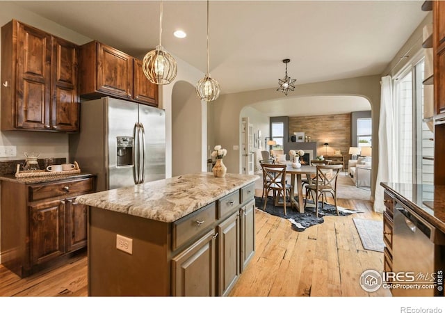 2315 Haymeadow Way, Fort Collins, CO 80525 - kitchen featuring arched walkways, appliances with stainless steel finishes, light wood-style floors, light stone counters, and open floor plan