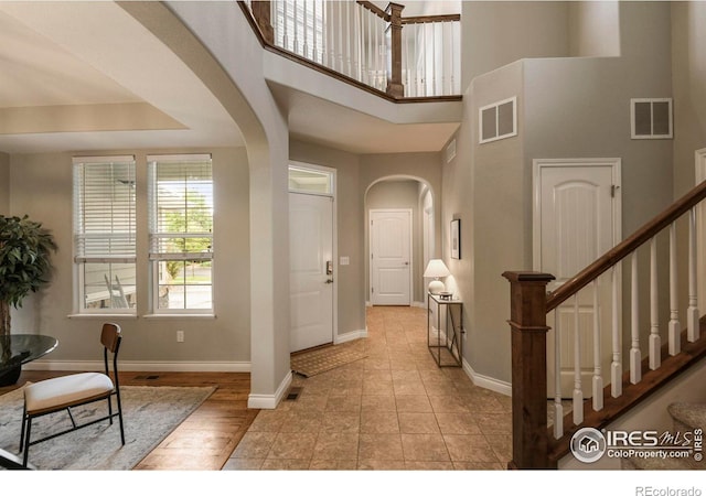 2315 Haymeadow Way, Fort Collins, CO 80525 - foyer entrance featuring arched walkways, baseboards, stairs, and a towering ceiling
