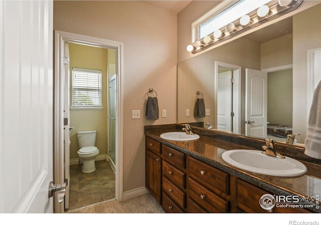 2315 Haymeadow Way, Fort Collins, CO 80525 - bathroom featuring double vanity, toilet, a shower stall, baseboards, and ensuite bath