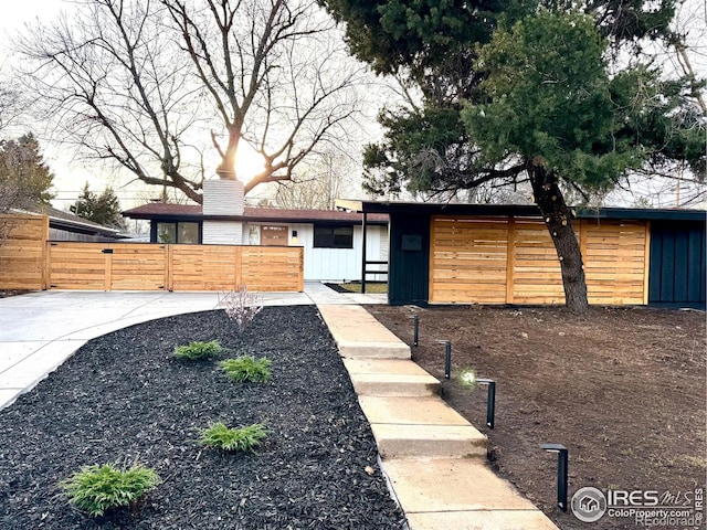 2435 S Meade St, Denver, CO 80219 - view of front of house with a fenced front yard, a chimney, and board and batten siding
