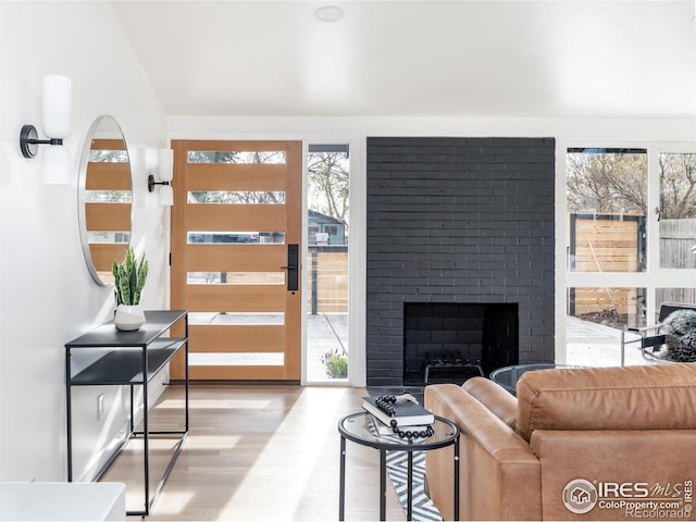 2435 S Meade St, Denver, CO 80219 - living room featuring healthy amount of natural light, wood finished floors, and a brick fireplace