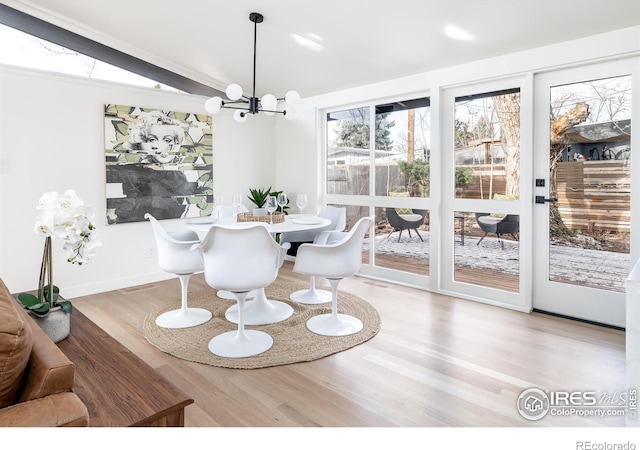 2435 S Meade St, Denver, CO 80219 - dining area with wood finished floors, a chandelier, and baseboards
