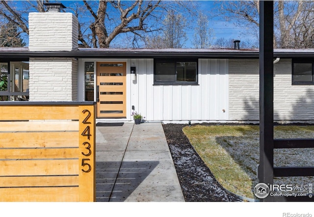 2435 S Meade St, Denver, CO 80219 - property entrance featuring a chimney and board and batten siding