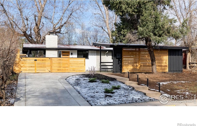2435 S Meade St, Denver, CO 80219 - mid-century modern home featuring a chimney and board and batten siding