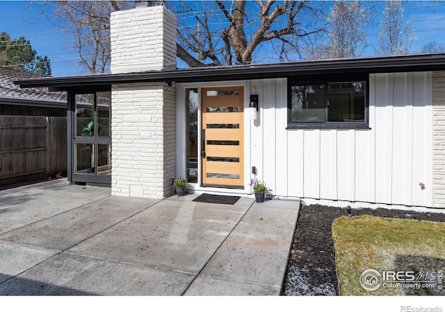 2435 S Meade St, Denver, CO 80219 - entrance to property featuring a chimney, board and batten siding, and a patio