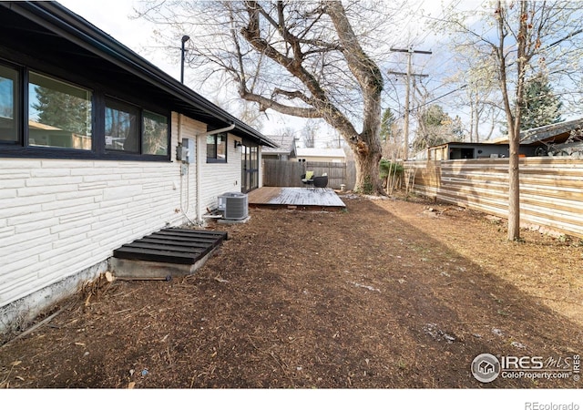 2435 S Meade St, Denver, CO 80219 - fenced backyard featuring a deck and central AC unit