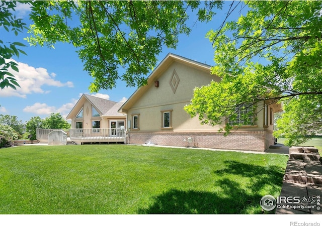6239 Ashcroft Rd, Greeley, CO 80634 - back of house with stucco siding, a yard, a deck, and brick siding