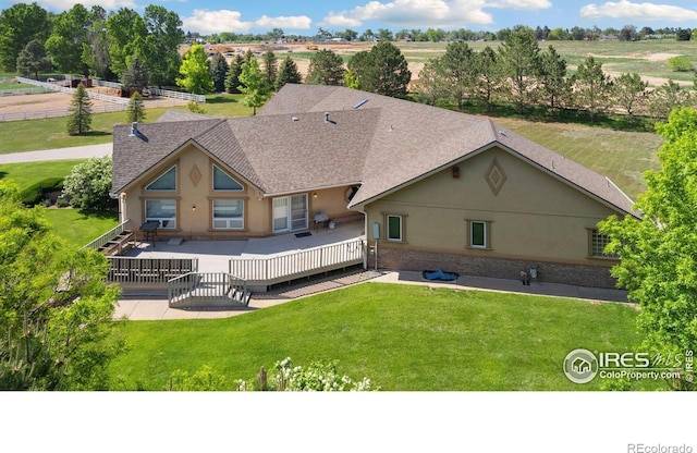 6239 Ashcroft Rd, Greeley, CO 80634 - back of property with stucco siding, a shingled roof, and a wooden deck