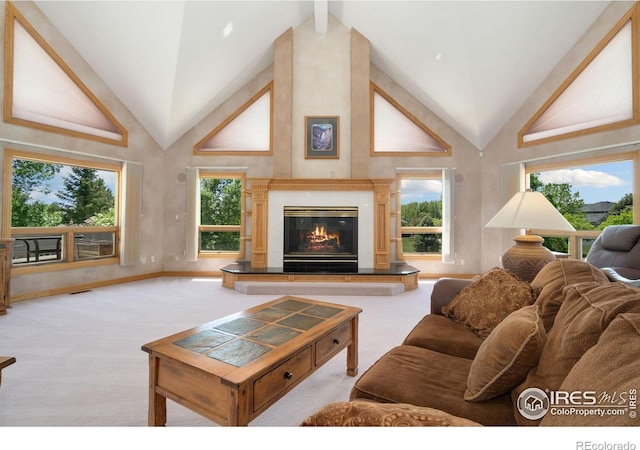 6239 Ashcroft Rd, Greeley, CO 80634 - living area with high vaulted ceiling, a glass covered fireplace, and carpet