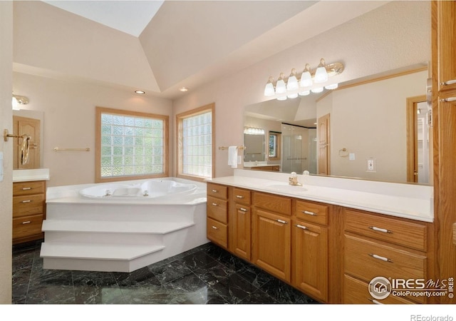 6239 Ashcroft Rd, Greeley, CO 80634 - full bathroom featuring marble finish flooring, vanity, a garden tub, a shower stall, and vaulted ceiling