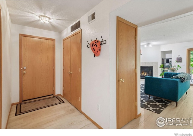 2802 Sundown Ln Unit 102, Boulder, CO 80303 - entryway with wood finished floors, a textured ceiling, and a tile fireplace