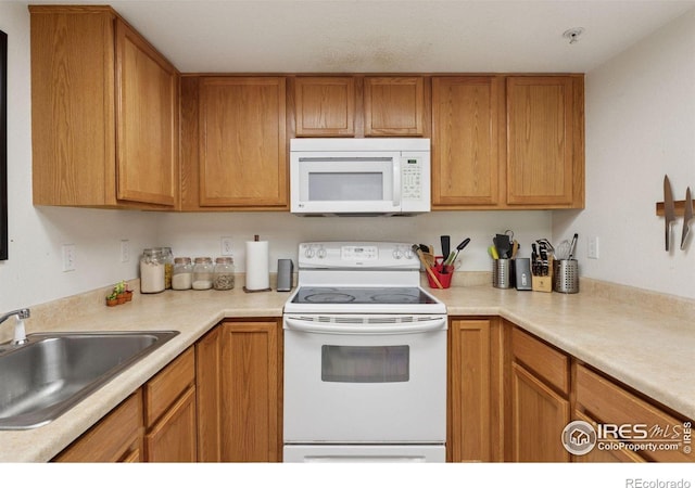 2802 Sundown Ln Unit 102, Boulder, CO 80303 - kitchen featuring white appliances, a sink, light countertops, and brown cabinets