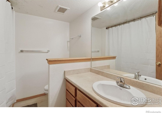 2802 Sundown Ln Unit 102, Boulder, CO 80303 - full bathroom featuring vanity, toilet, and a textured ceiling