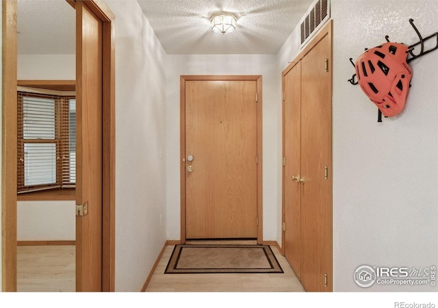 2802 Sundown Ln Unit 102, Boulder, CO 80303 - doorway to outside with a textured ceiling and baseboards