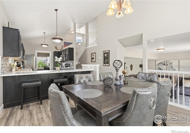 9930 Cascade St, Firestone, CO 80504 - dining space featuring light wood-style floors, stairs, a chandelier, and vaulted ceiling