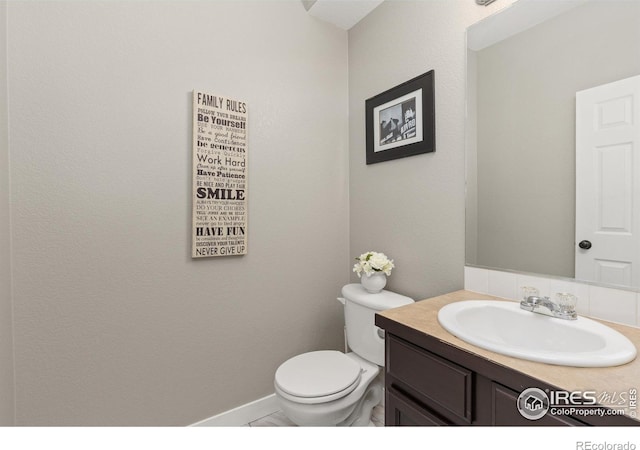 9930 Cascade St, Firestone, CO 80504 - half bathroom with vanity, toilet, and baseboards