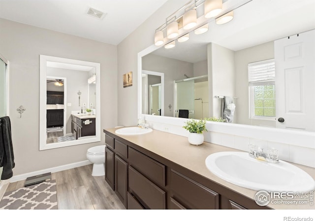9930 Cascade St, Firestone, CO 80504 - bathroom with a shower stall, double vanity, ceiling fan, toilet, and ensuite bath