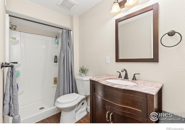 9930 Cascade St, Firestone, CO 80504 - bathroom featuring toilet, vanity, curtained shower, and wood finished floors